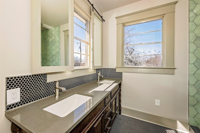 full bathroom featuring double vanity, a healthy amount of sunlight, and a sink