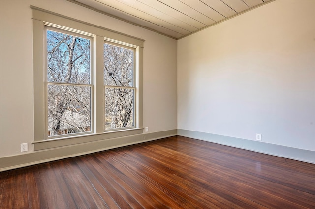 empty room featuring dark wood-style floors and a healthy amount of sunlight