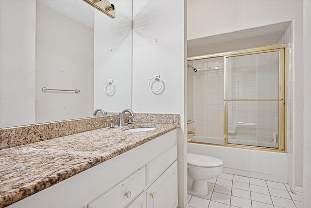 full bathroom with combined bath / shower with glass door, toilet, tile patterned flooring, and vanity