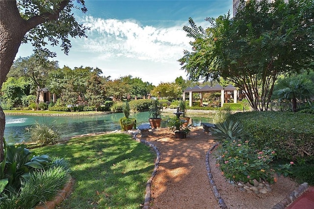 view of home's community featuring a lawn and a water view