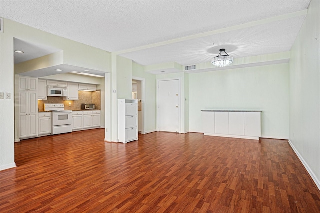 unfurnished living room featuring dark wood-style flooring, a textured ceiling, visible vents, and an inviting chandelier