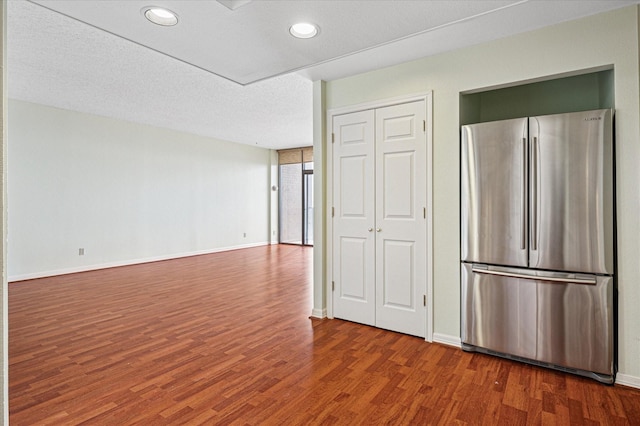kitchen with baseboards, wood finished floors, and freestanding refrigerator