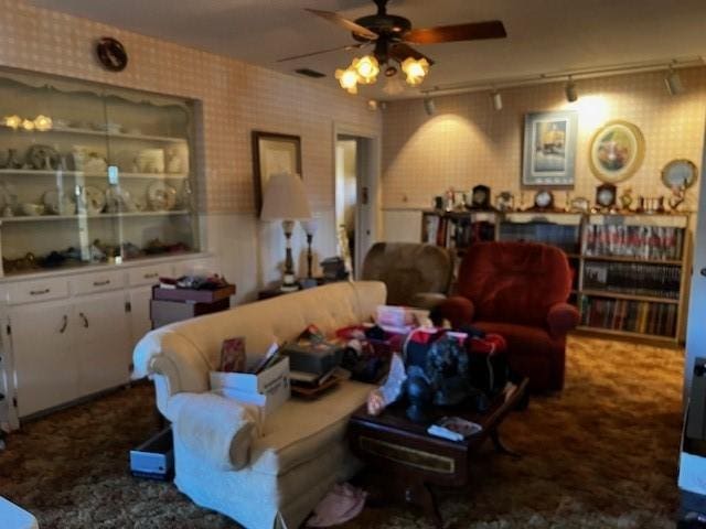 carpeted living room with wallpapered walls, ceiling fan, and rail lighting