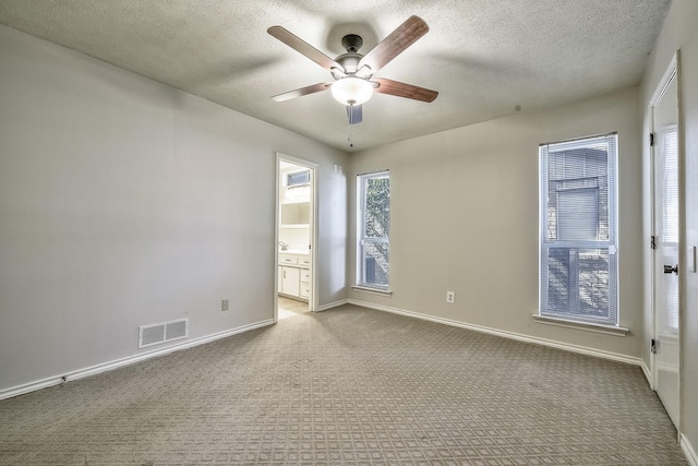 spare room featuring ceiling fan, baseboards, visible vents, and light colored carpet