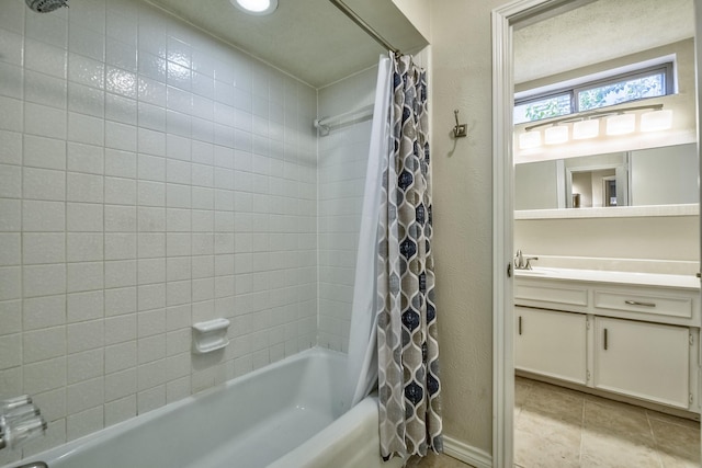 bathroom featuring shower / bathtub combination with curtain, vanity, tile patterned flooring, and a textured wall