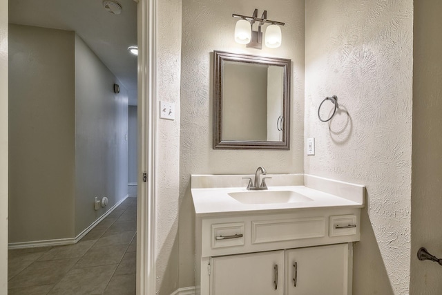 bathroom featuring a textured wall, tile patterned floors, and vanity