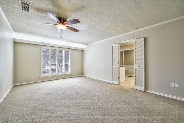 unfurnished bedroom with carpet, crown molding, visible vents, a textured ceiling, and baseboards