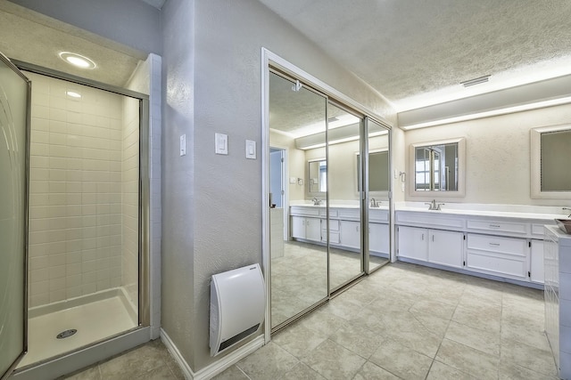 bathroom with a textured ceiling, a textured wall, a shower stall, and heating unit