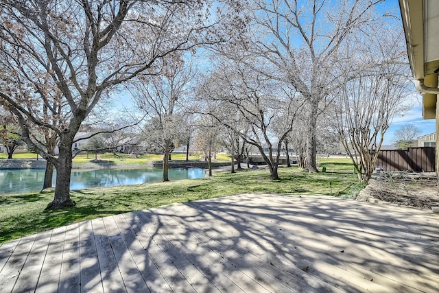 view of home's community with a lawn and a deck with water view