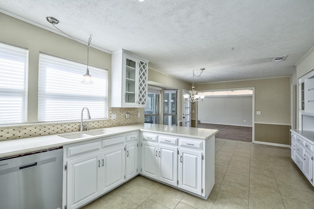 kitchen with white cabinets, glass insert cabinets, a peninsula, a sink, and stainless steel dishwasher