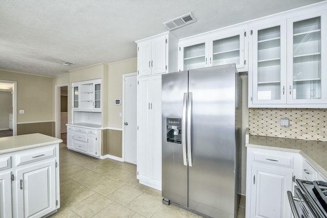 kitchen with light countertops, appliances with stainless steel finishes, visible vents, and white cabinets