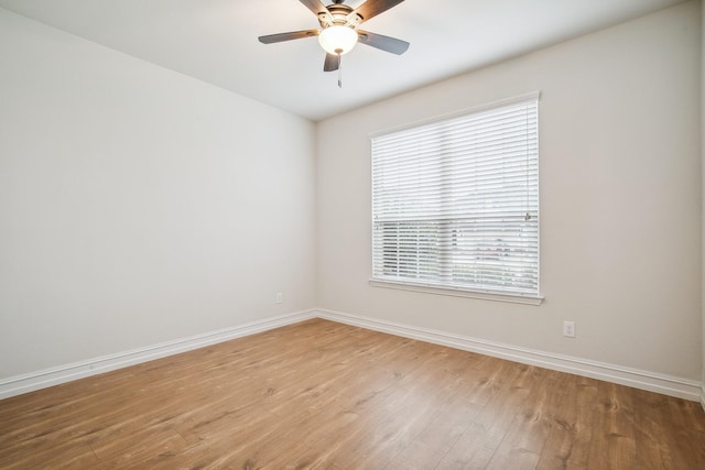 spare room featuring wood finished floors, a ceiling fan, and baseboards