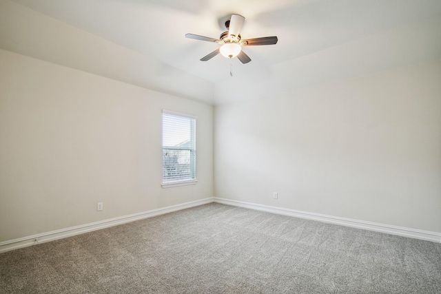 spare room with a ceiling fan, carpet, vaulted ceiling, and baseboards