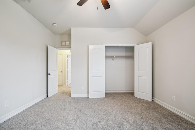 unfurnished bedroom featuring a closet, baseboards, vaulted ceiling, and carpet flooring