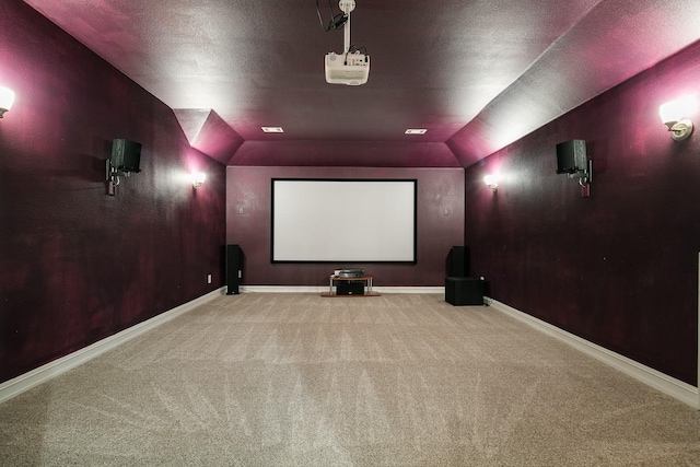 home theater with carpet floors, lofted ceiling, a textured ceiling, and baseboards