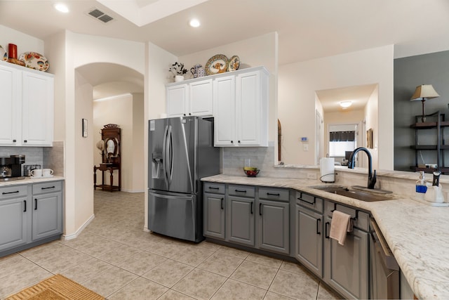 kitchen featuring arched walkways, a sink, white cabinetry, stainless steel refrigerator with ice dispenser, and gray cabinets