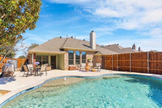 view of swimming pool with a fenced backyard, a fenced in pool, and a patio