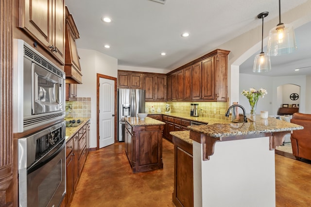 kitchen with concrete flooring, light stone counters, a peninsula, stainless steel appliances, and a kitchen bar