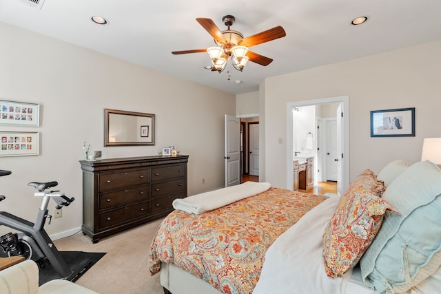 bedroom with recessed lighting, ensuite bathroom, light carpet, ceiling fan, and baseboards