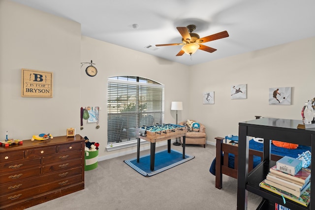 rec room with light colored carpet, visible vents, ceiling fan, and baseboards