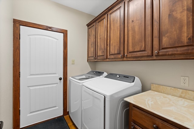 clothes washing area with cabinet space and separate washer and dryer