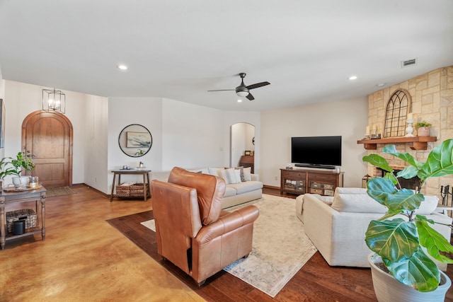 living area with arched walkways, visible vents, recessed lighting, and ceiling fan with notable chandelier