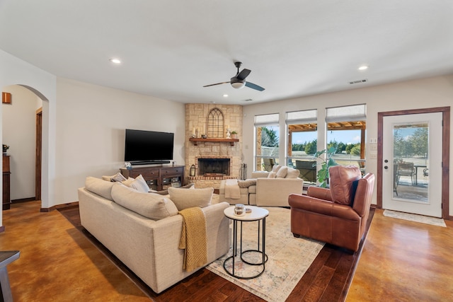 living room featuring arched walkways, a fireplace, recessed lighting, visible vents, and a ceiling fan