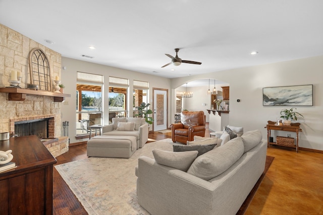 living area with arched walkways, recessed lighting, a fireplace, wood finished floors, and baseboards