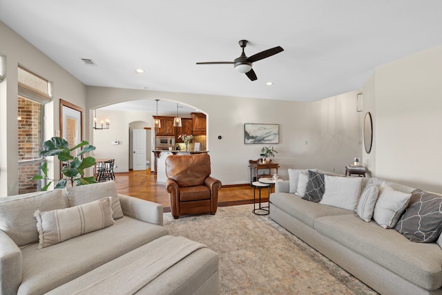 living area with baseboards, visible vents, arched walkways, a ceiling fan, and recessed lighting