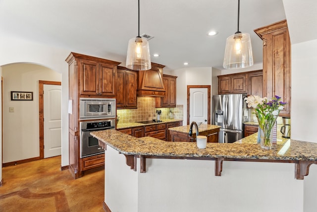 kitchen with premium range hood, appliances with stainless steel finishes, and a breakfast bar