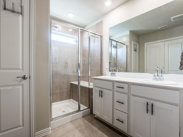 full bathroom with visible vents, a sink, and a shower stall