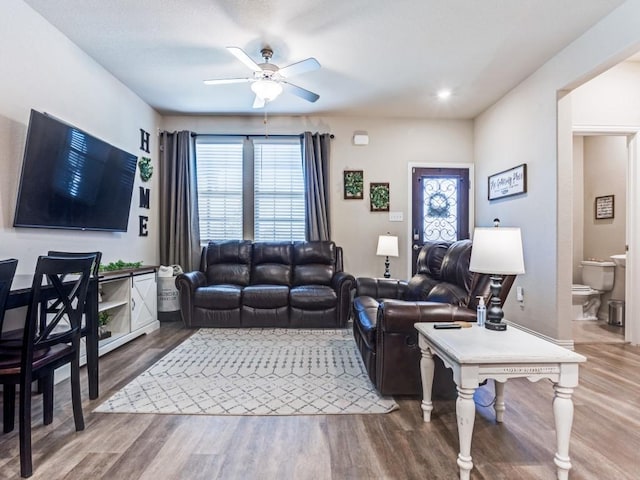 living room featuring ceiling fan, a wealth of natural light, and wood finished floors