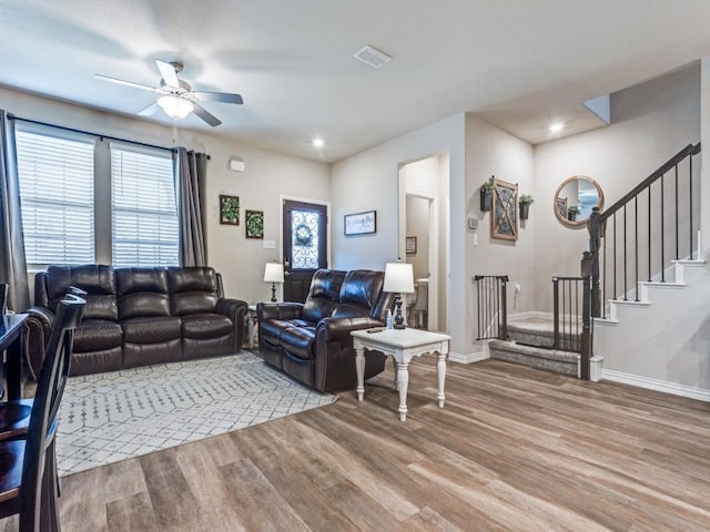 living room featuring a wealth of natural light, baseboards, stairway, and wood finished floors