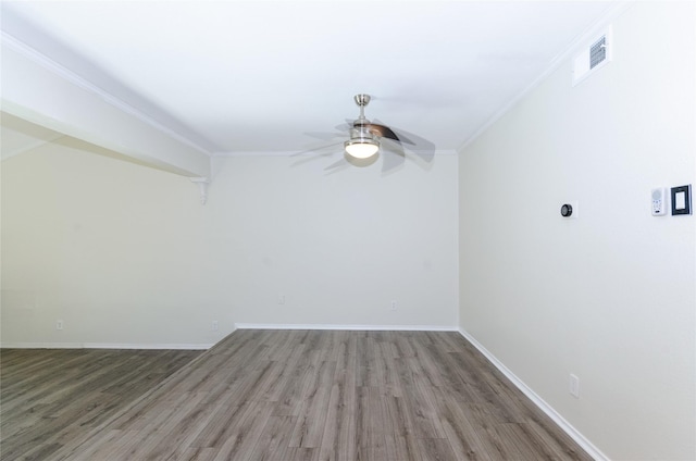 unfurnished room featuring baseboards, visible vents, ceiling fan, ornamental molding, and wood finished floors