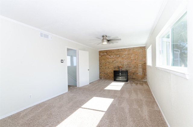 unfurnished living room with ceiling fan, light colored carpet, visible vents, ornamental molding, and a wood stove