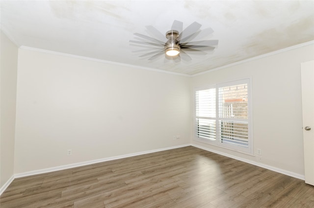 spare room featuring baseboards, ornamental molding, and wood finished floors