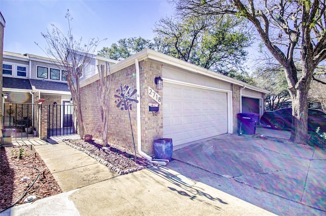 exterior space with concrete driveway, brick siding, and an attached garage