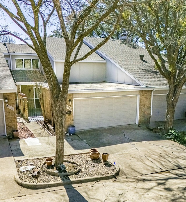 view of front of house featuring driveway, brick siding, roof with shingles, and an attached garage