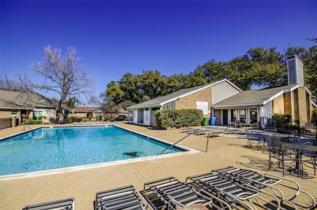 pool with fence and a patio