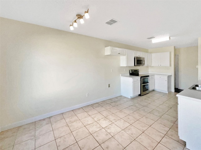 kitchen with appliances with stainless steel finishes, light countertops, visible vents, and white cabinetry