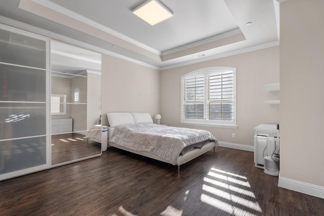 bedroom featuring dark wood-type flooring, visible vents, baseboards, a raised ceiling, and crown molding