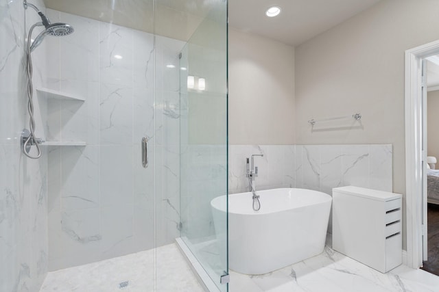 full bathroom featuring a soaking tub, a marble finish shower, marble finish floor, and recessed lighting