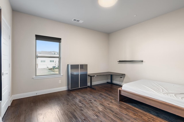 unfurnished bedroom featuring dark wood-style floors, baseboards, and visible vents