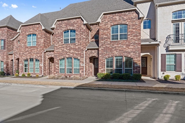 multi unit property with brick siding and roof with shingles