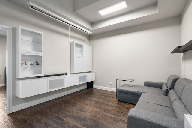 living area with dark wood-style flooring and baseboards