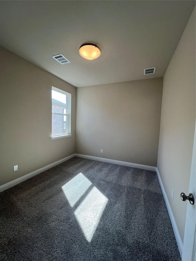 empty room with carpet floors, visible vents, and baseboards