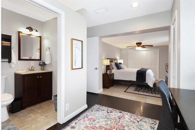 bedroom with a ceiling fan, a sink, baseboards, and light tile patterned floors