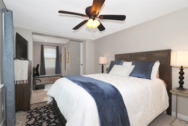 tiled bedroom with baseboards and a ceiling fan