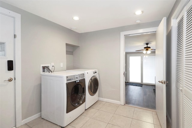 laundry area with light tile patterned floors, laundry area, baseboards, and washer and dryer