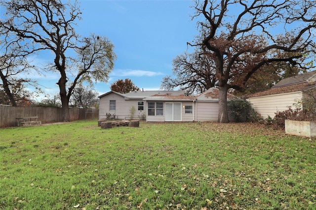 rear view of property with a yard and fence